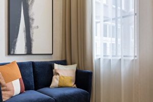 blauwe bank met gekleurde kussens in schevenings appartement