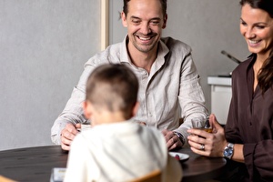 gezin drinkt thee bij de eettafel en lachen in hotel in Scheveningen