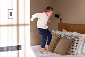 Kind springt auf Bett in Scheveningen